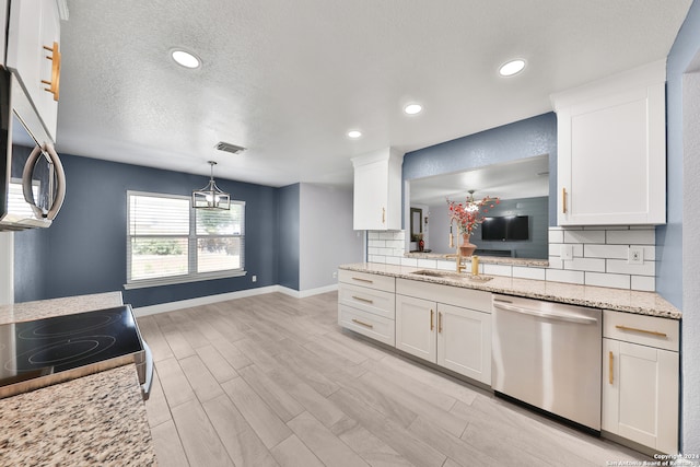 kitchen with light stone counters, white cabinets, stainless steel appliances, and light wood-type flooring