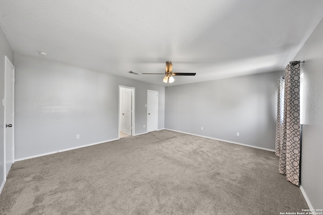 carpeted spare room with ceiling fan