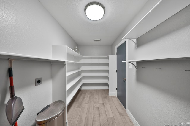 walk in closet featuring light hardwood / wood-style flooring