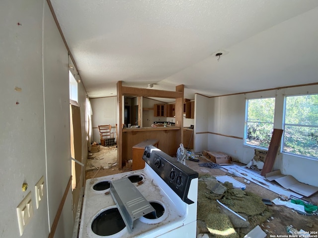 kitchen with vaulted ceiling, a textured ceiling, and washer / dryer