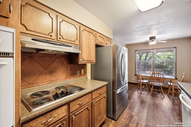 kitchen with tasteful backsplash, ceiling fan, appliances with stainless steel finishes, and dark hardwood / wood-style flooring