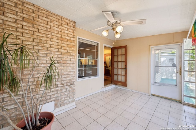 unfurnished sunroom with ceiling fan