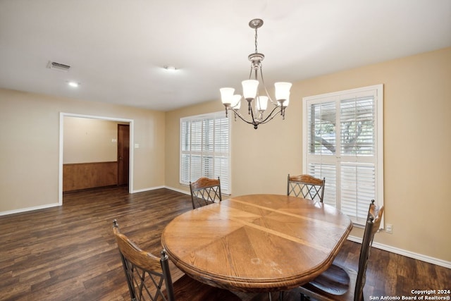 dining space featuring dark hardwood / wood-style floors and a chandelier