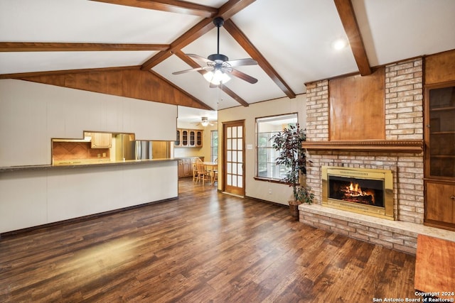 unfurnished living room featuring ceiling fan, dark hardwood / wood-style floors, vaulted ceiling with beams, and a fireplace