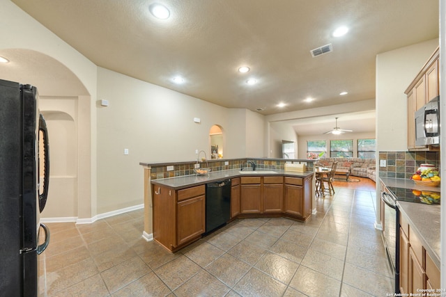 kitchen featuring kitchen peninsula, appliances with stainless steel finishes, sink, and ceiling fan