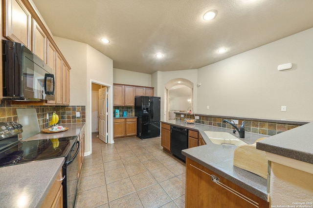 kitchen with light tile patterned flooring, black appliances, sink, and tasteful backsplash