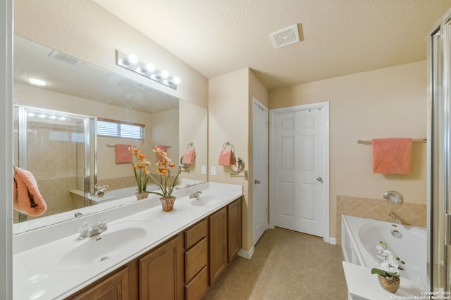 bathroom featuring vanity, plus walk in shower, tile patterned flooring, and a textured ceiling