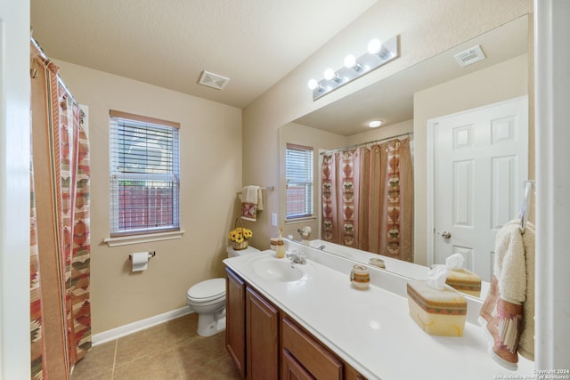 bathroom featuring vanity, tile patterned floors, toilet, and a wealth of natural light