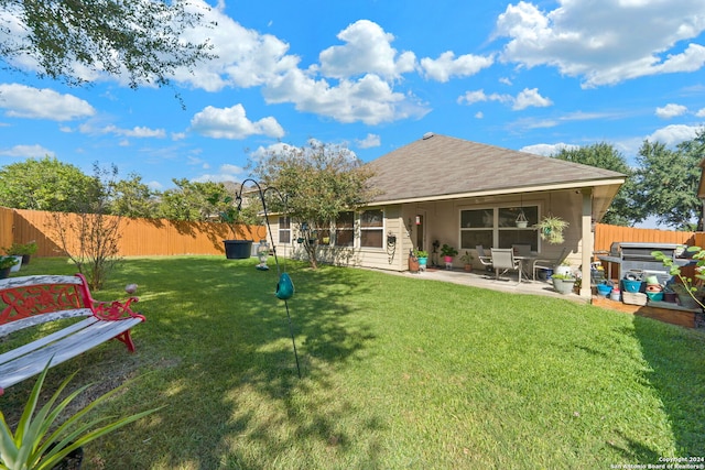 back of property with a yard and a patio area