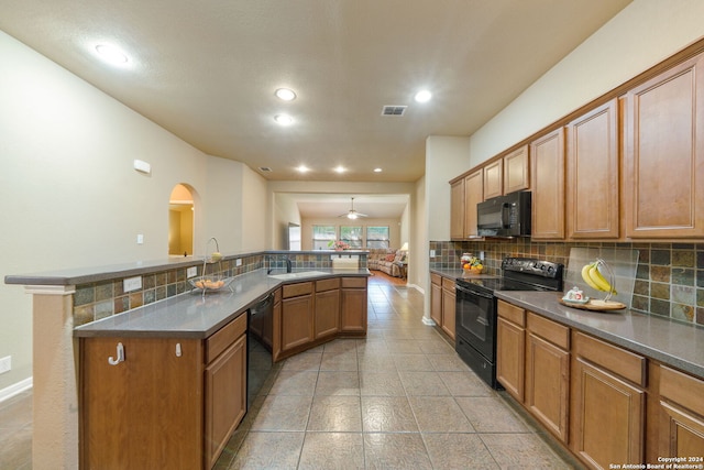 kitchen with black appliances, sink, and backsplash