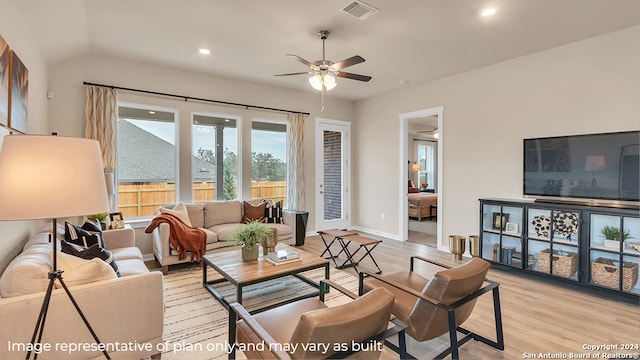 living room with vaulted ceiling, light hardwood / wood-style flooring, and ceiling fan