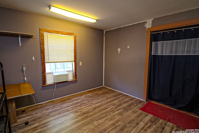 unfurnished room with cooling unit and hardwood / wood-style flooring