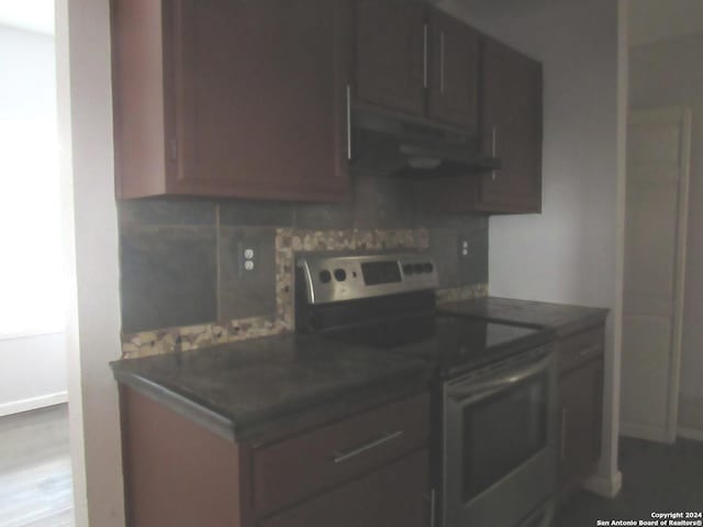 7731 Clear Ridge Dr, San Antonio, TX 78239 - kitchen featuring backsplash, under cabinet range hood, electric stove, and dark countertops