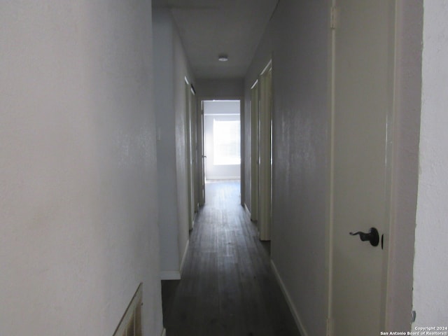 corridor with dark hardwood / wood-style flooring