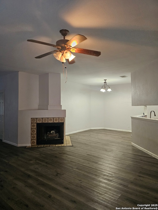 7731 Clear Ridge Dr, San Antonio, TX 78239 - unfurnished living room featuring a ceiling fan, wood finished floors, a fireplace, baseboards, and visible vents