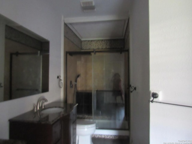 bathroom featuring vanity, a shower with shower door, and toilet