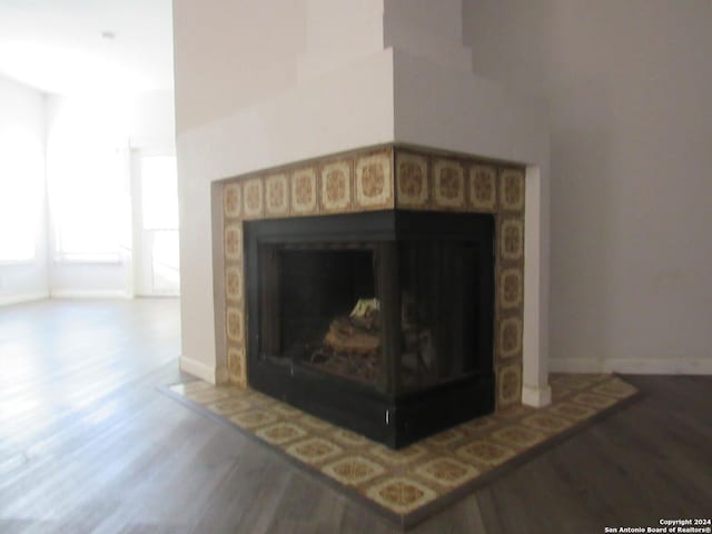 7731 Clear Ridge Dr, San Antonio, TX 78239 - details featuring a tiled fireplace, baseboards, and wood finished floors