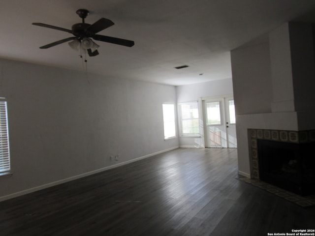 unfurnished living room with ceiling fan, dark hardwood / wood-style flooring, and a fireplace