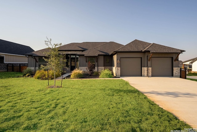 prairie-style home featuring a front yard and a garage