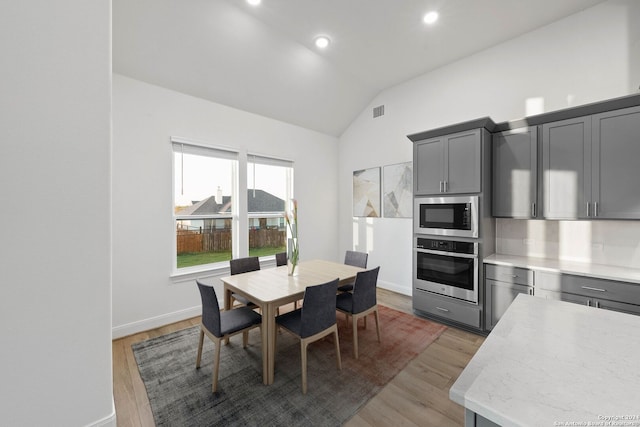 dining space featuring vaulted ceiling and dark hardwood / wood-style flooring