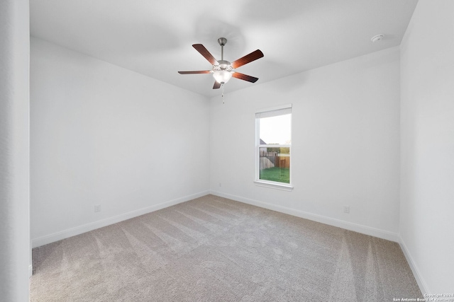 unfurnished room with ceiling fan and carpet