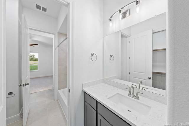 bathroom featuring tiled shower / bath, vanity, and tile patterned floors