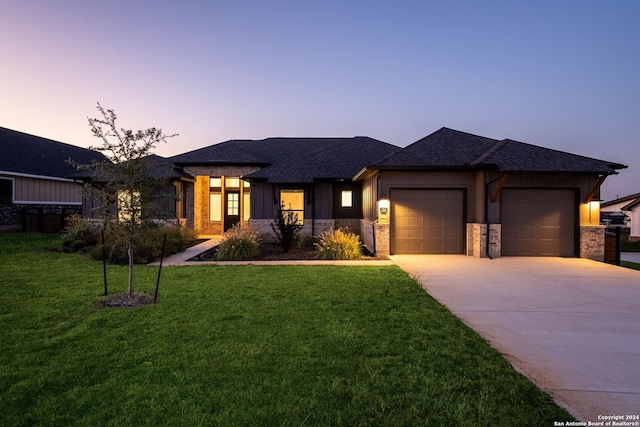 prairie-style house featuring a garage and a lawn