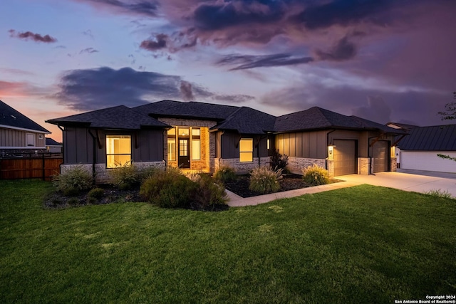 prairie-style home featuring a yard and a garage