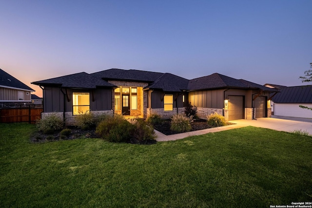 prairie-style home with a yard and a garage