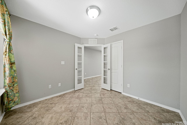 unfurnished bedroom featuring french doors