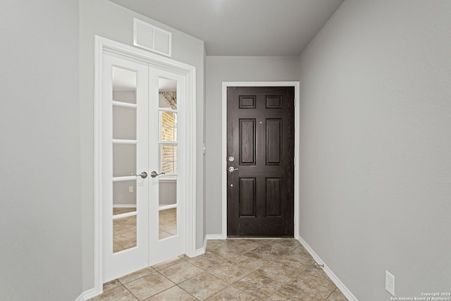 entryway with french doors and light tile patterned flooring