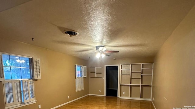 unfurnished bedroom featuring ceiling fan, hardwood / wood-style floors, and a textured ceiling