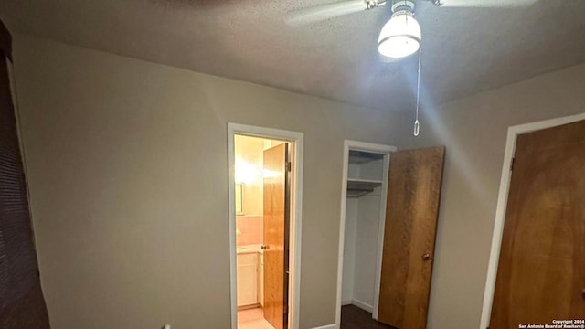 unfurnished bedroom with a closet, connected bathroom, and ceiling fan