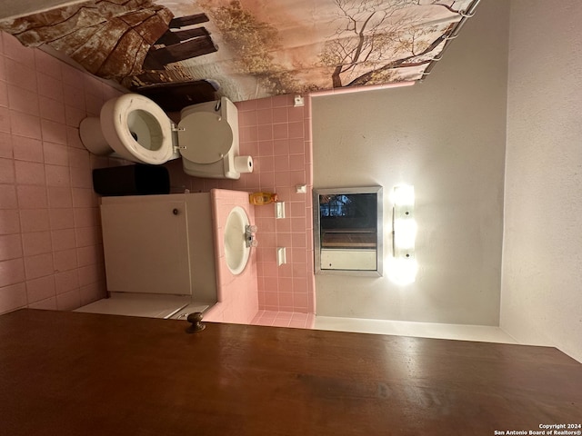 bathroom featuring tile walls and toilet