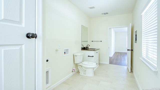 bathroom featuring a healthy amount of sunlight, vanity, and toilet