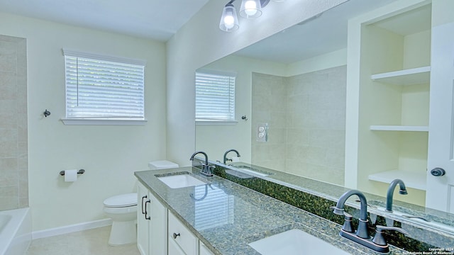 bathroom featuring tile patterned flooring, a tub to relax in, vanity, and toilet