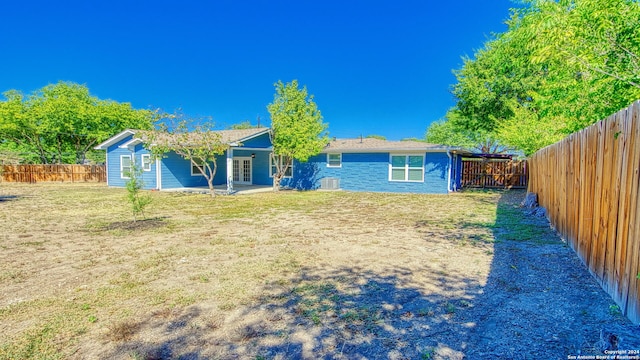 rear view of property featuring a yard and a patio area