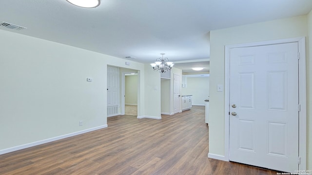 spare room with hardwood / wood-style flooring and a chandelier