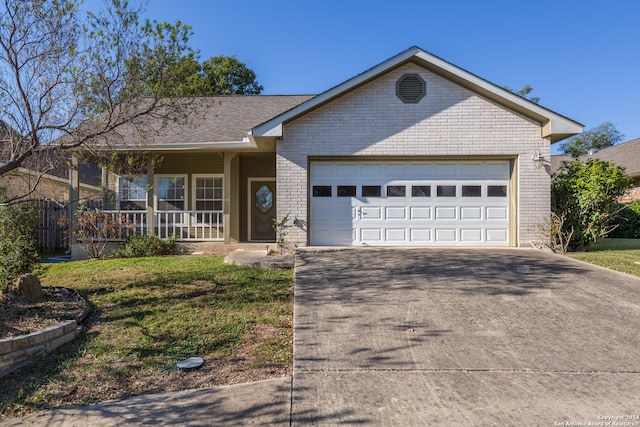 ranch-style home featuring a garage, a front lawn, and covered porch