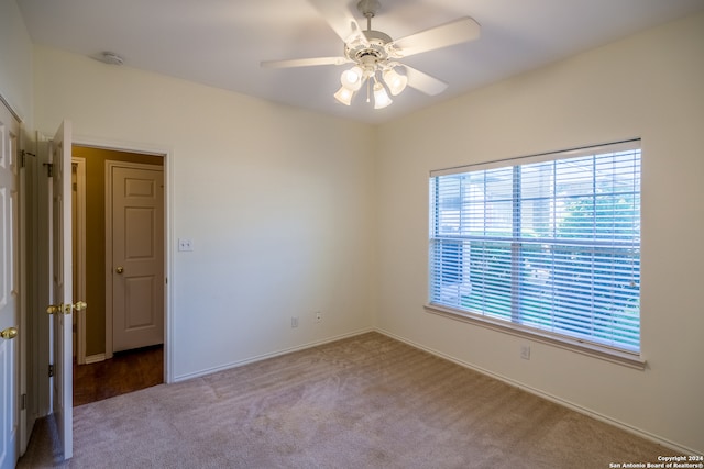 carpeted spare room with ceiling fan