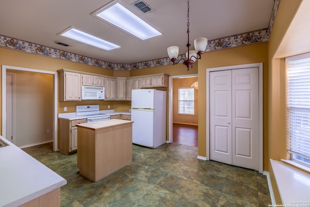 kitchen featuring white appliances, a kitchen island, decorative light fixtures, light brown cabinetry, and an inviting chandelier