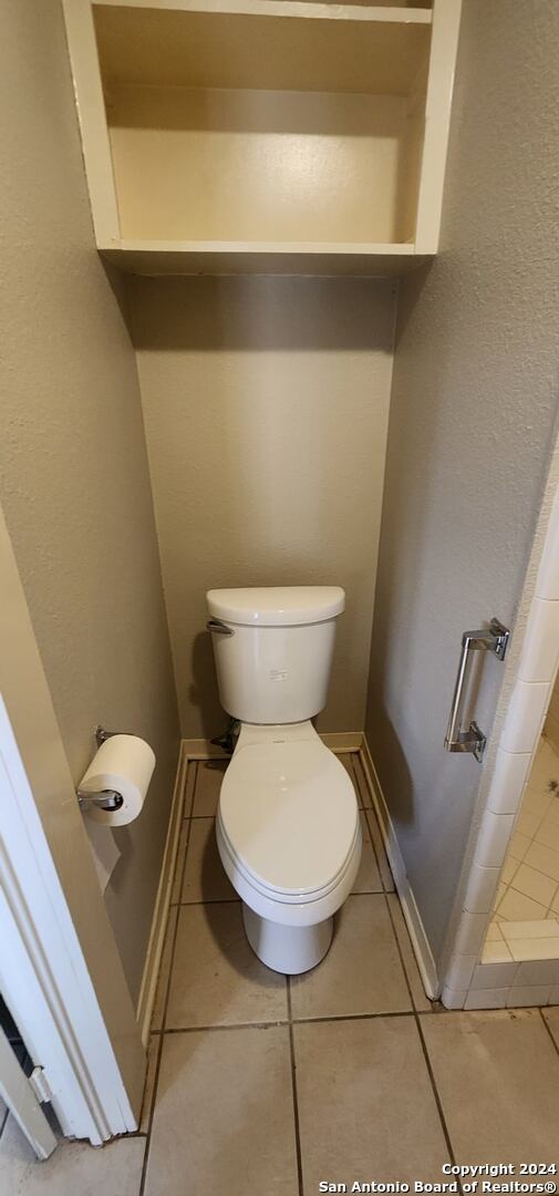 bathroom with toilet and tile patterned floors