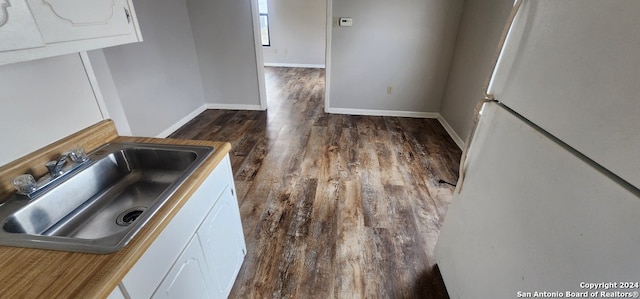 kitchen featuring white cabinets, white refrigerator, dark hardwood / wood-style floors, and sink