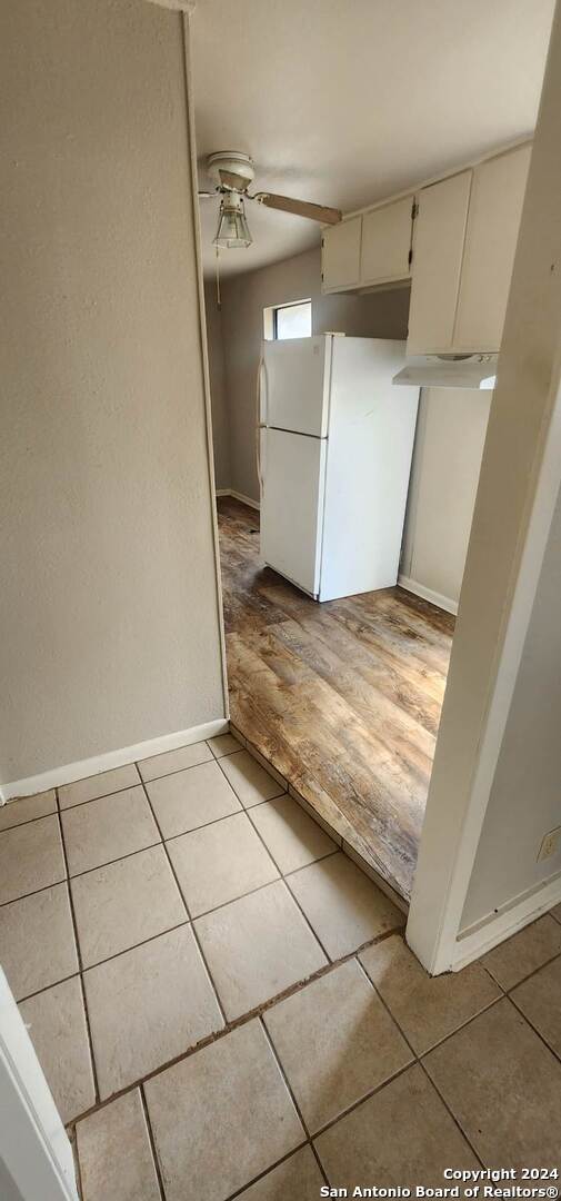 kitchen featuring light tile patterned floors, white fridge, and ceiling fan