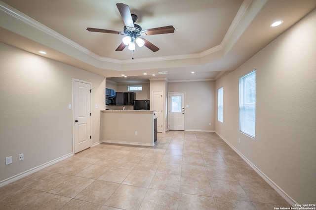 unfurnished living room featuring ceiling fan, light tile patterned floors, a tray ceiling, and ornamental molding