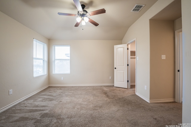 unfurnished room with lofted ceiling, ceiling fan, and carpet flooring