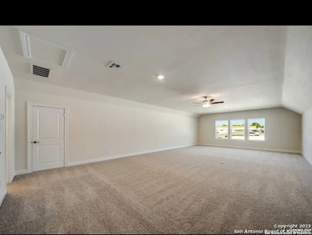 carpeted spare room with ceiling fan and vaulted ceiling