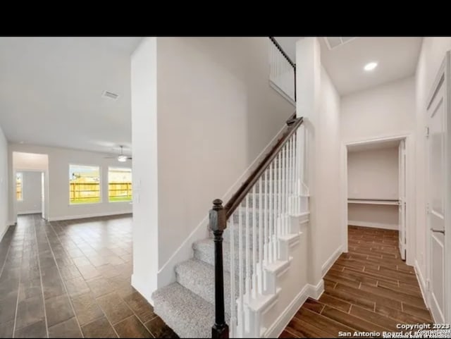 staircase with hardwood / wood-style flooring and ceiling fan