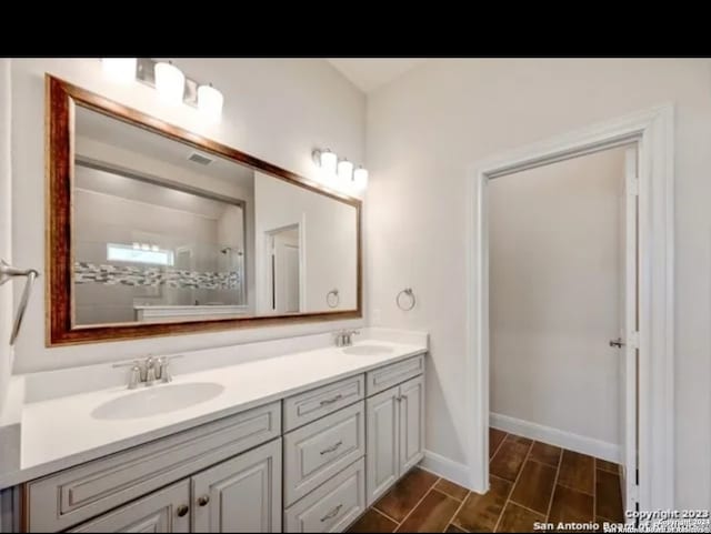 bathroom with vanity and tiled shower