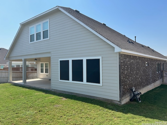 back of house featuring a lawn and a patio area